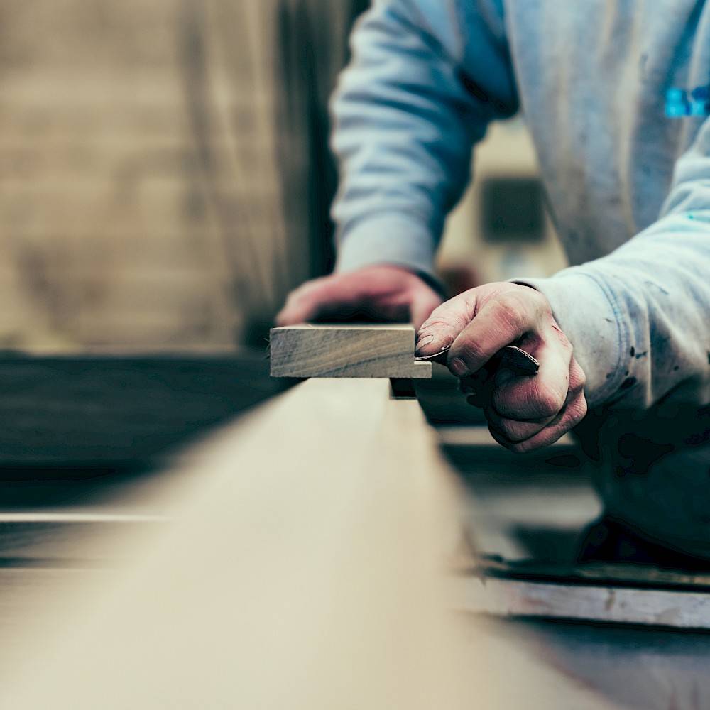 Medewerker van Vandenbussche schuurt hout