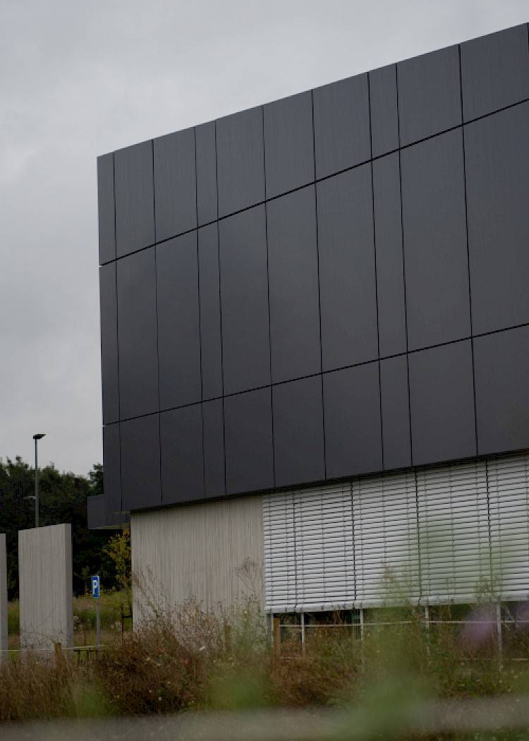 Modern kantoorgebouw met zwarte gevelbekleding uitgewerkt door Vandenbussche