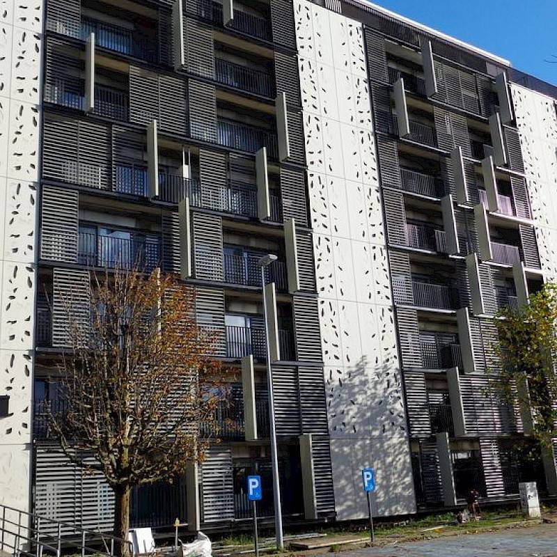 appartementsgebouwen in vezelcement met enkele bomen op de voorgrond